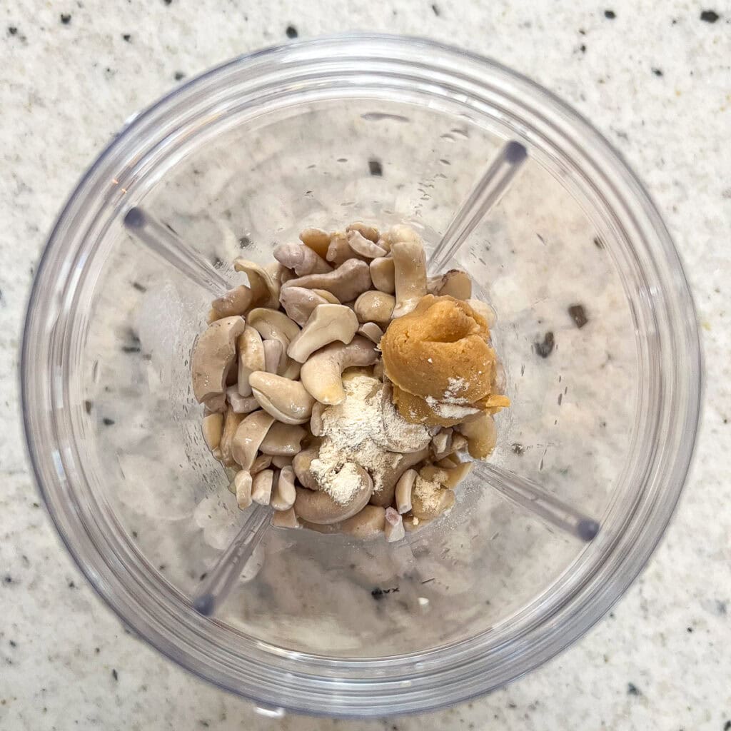 Cashews, miso paste, onion powder, lemon juice, coconut milk and vinegar in a blender cup.