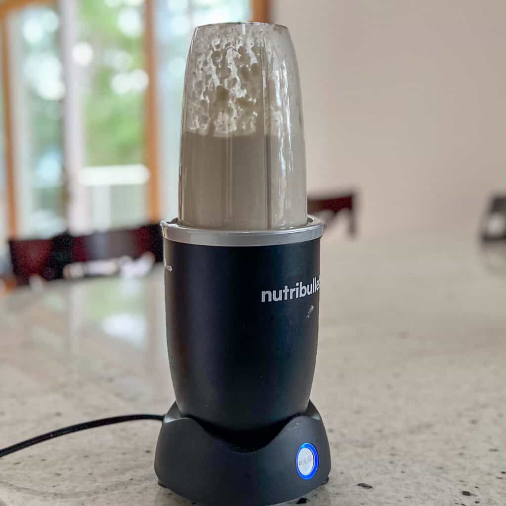 Cashew cream cheese being blended in a mini blender.