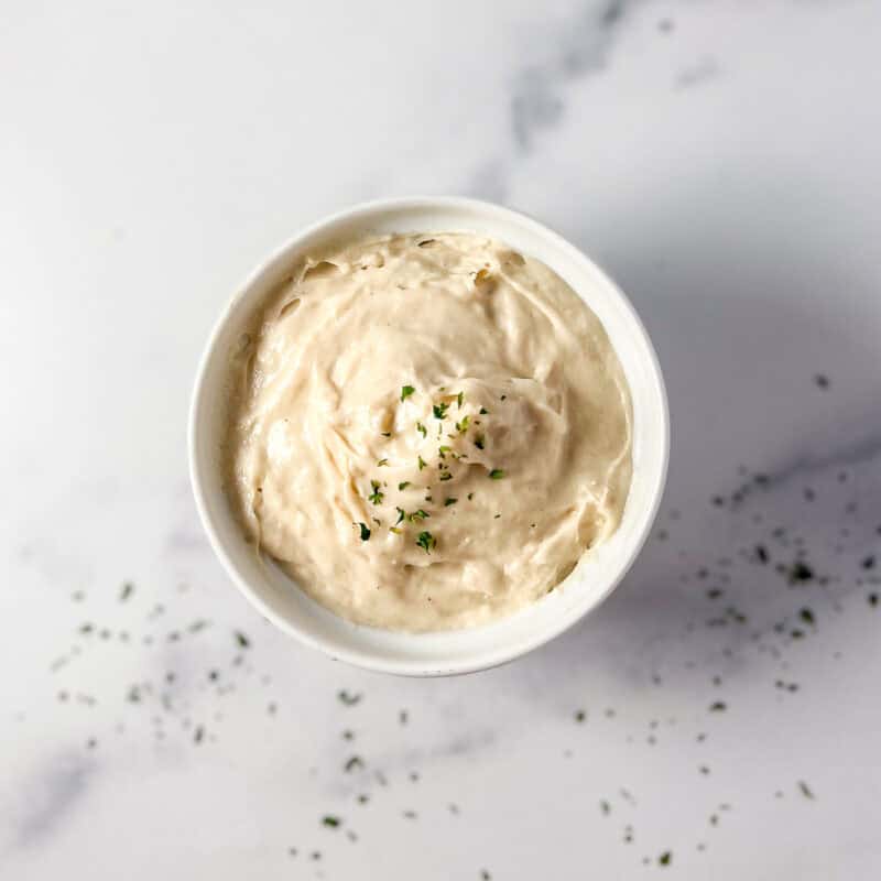 Vegan mozzarella in a dish topped with a dusting of dried herbs.