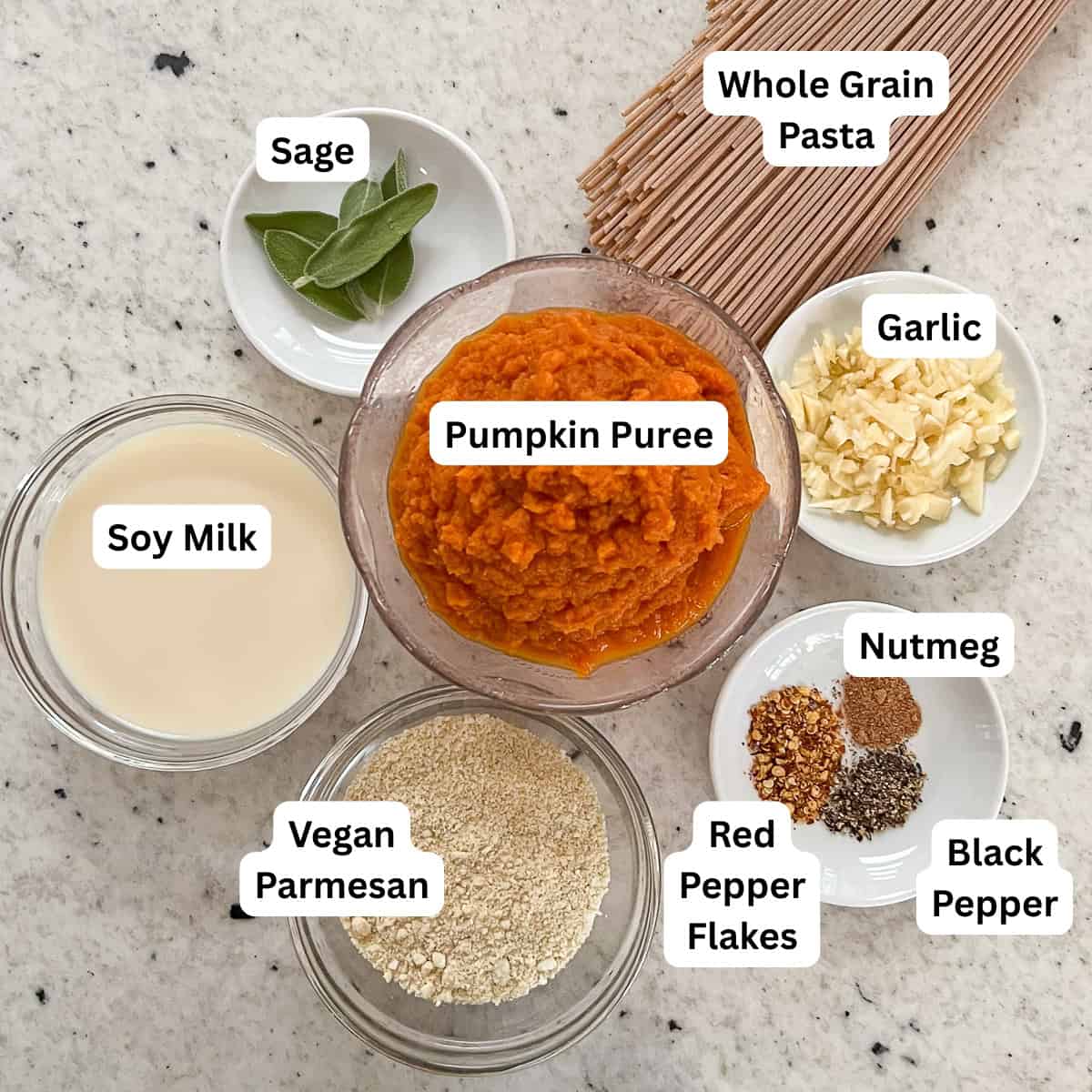 Ingredients for pumpkin pasta: pumpkin puree, garlic, soymilk, spices, whole grain pasta, cashew parmesan cheese and fresh sage.