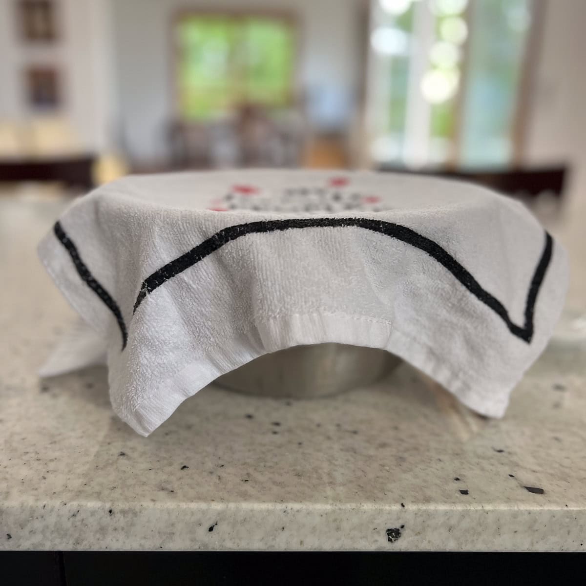 A clean tea towel covering a mixing bowl.