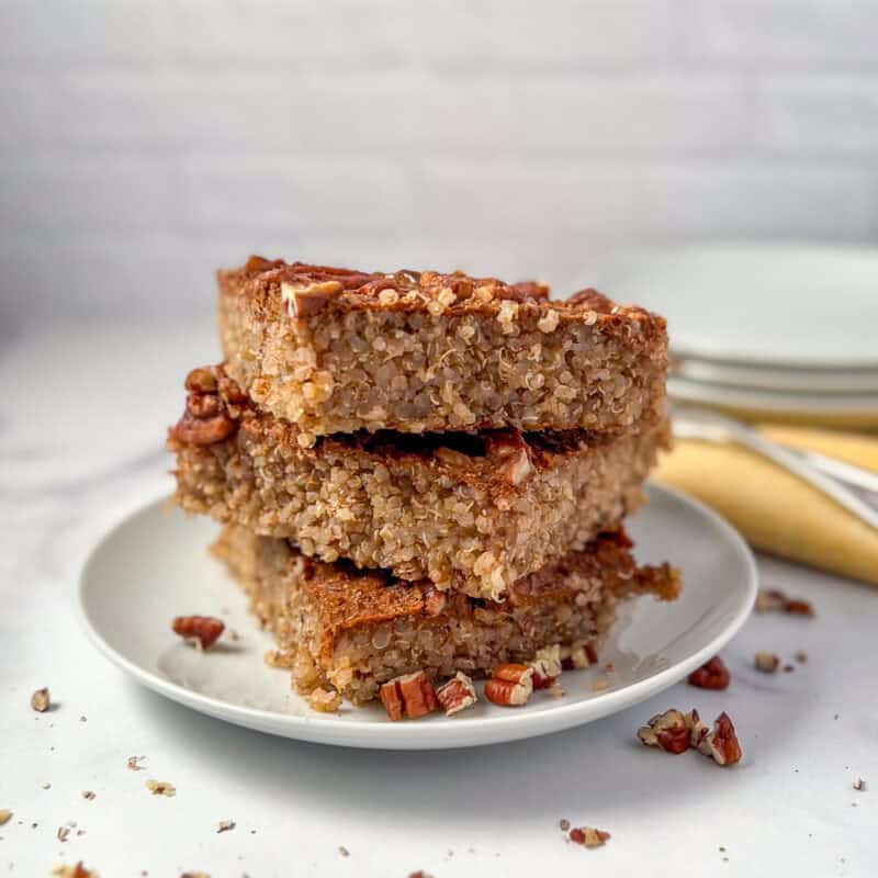 A stack of pumpkin spice quinoa breakfast bake on a plate with chopped pecans.