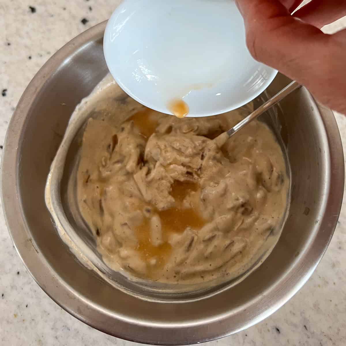 Lemon juice and apple cider vinegar being added to the bowl with other ingredients.