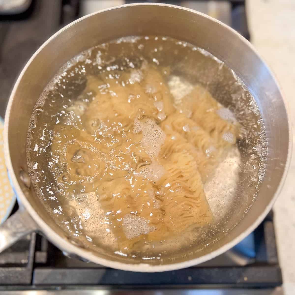 Ramen noodles boiling in a pot.