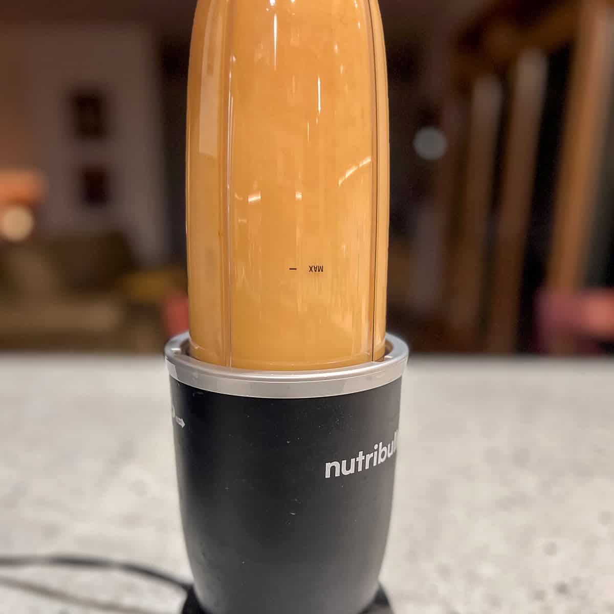 Red curry paste broth being blended in a blender.