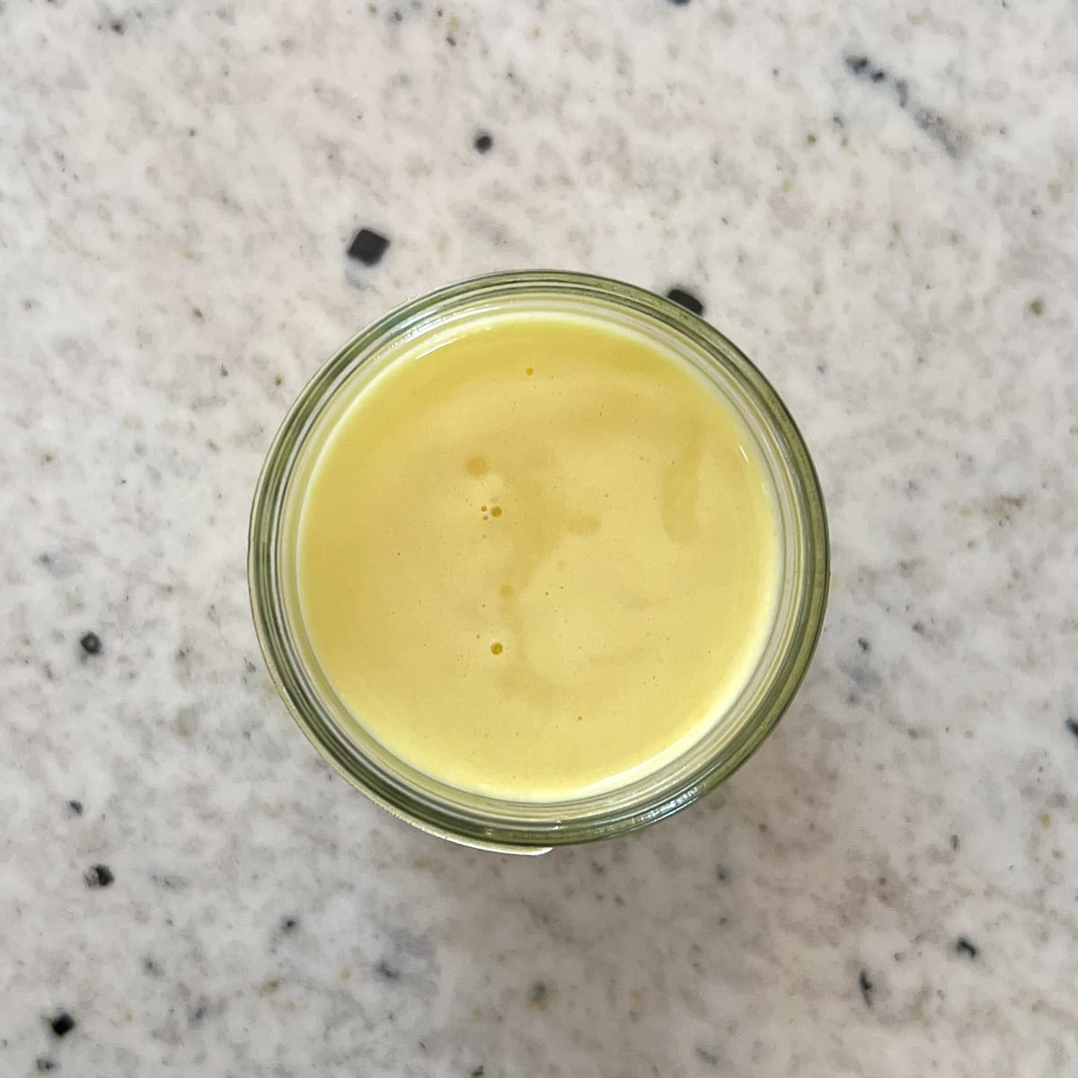 Close up of a lemon and ginger shot.