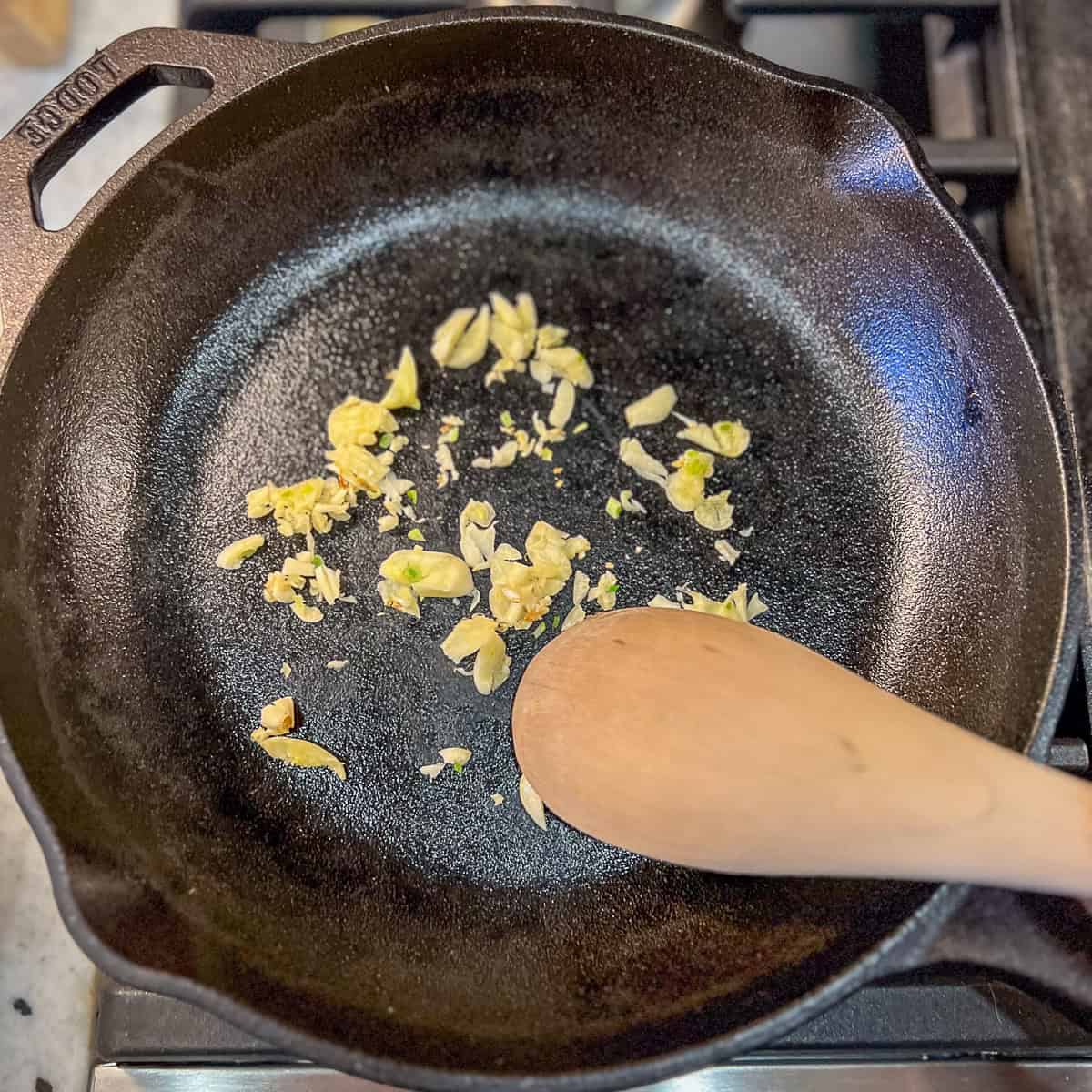 Garlic sautéing in a cast iron skillet.