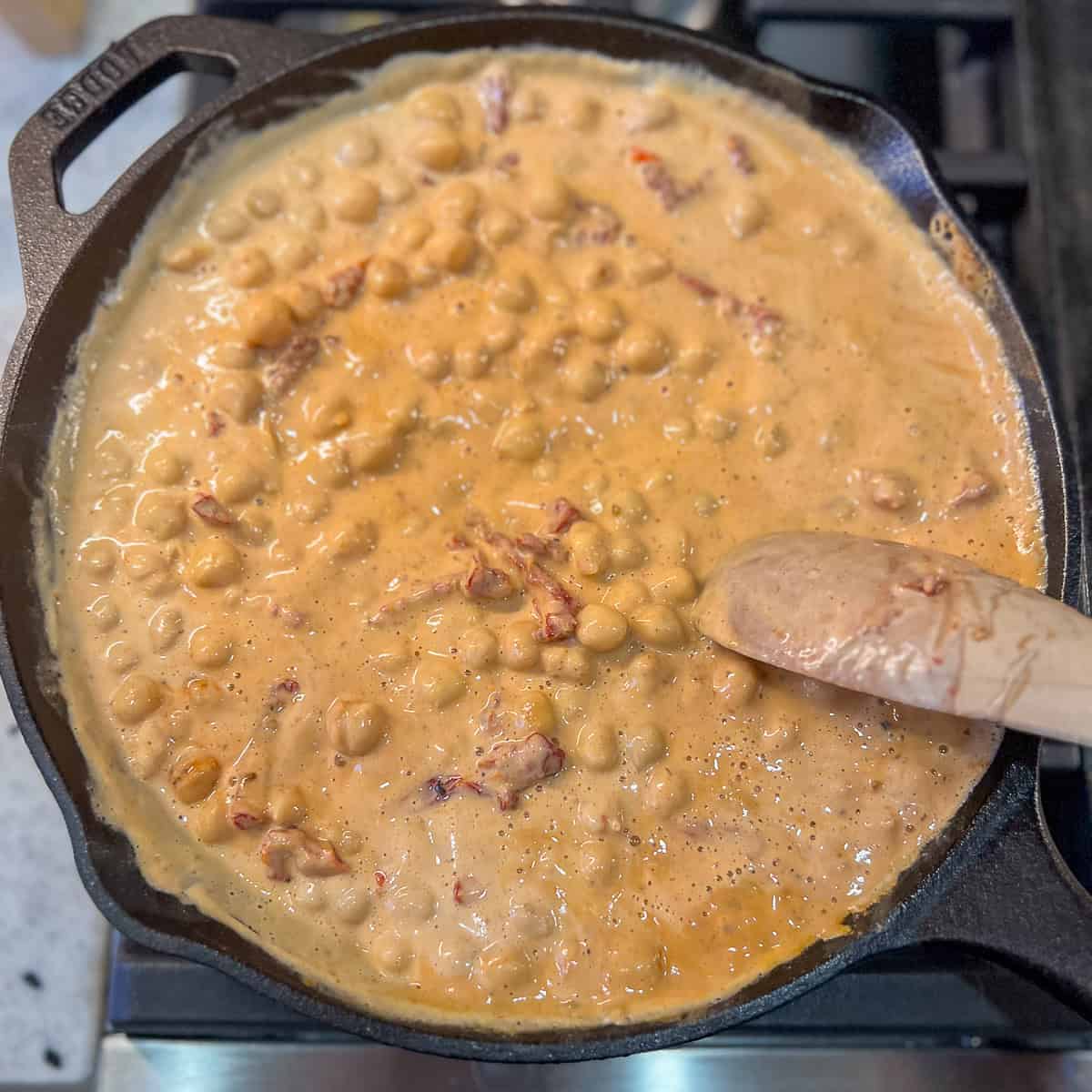 Cashew cream being stirred into the chickpeas.