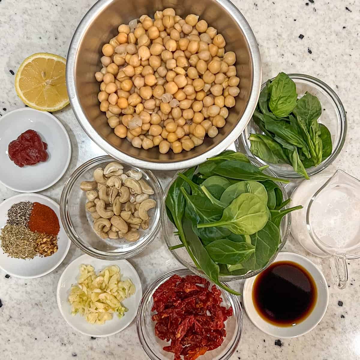 Ingredients for Marry Me Chickpeas: chickpeas, garlic, cashews, lemon, sundried tomatoes, oregano, smoked paprika, black pepper, crushed red pepper, aminos, tomato paste, plain unsweetened coconut milk, spinach and fresh basil.