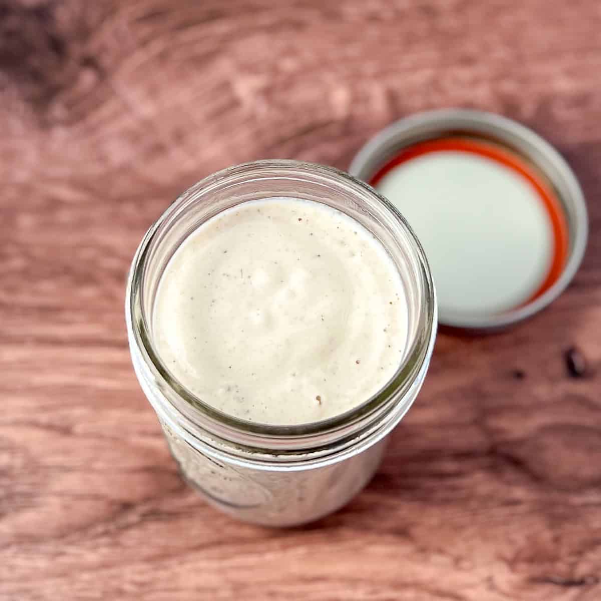 Oil-Free Greek dressing in a mason jar with lid on the side. 