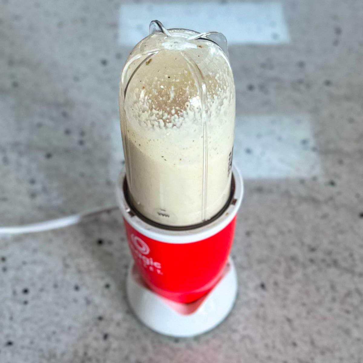 Oil free Greek dressing being blended in a mini blender.