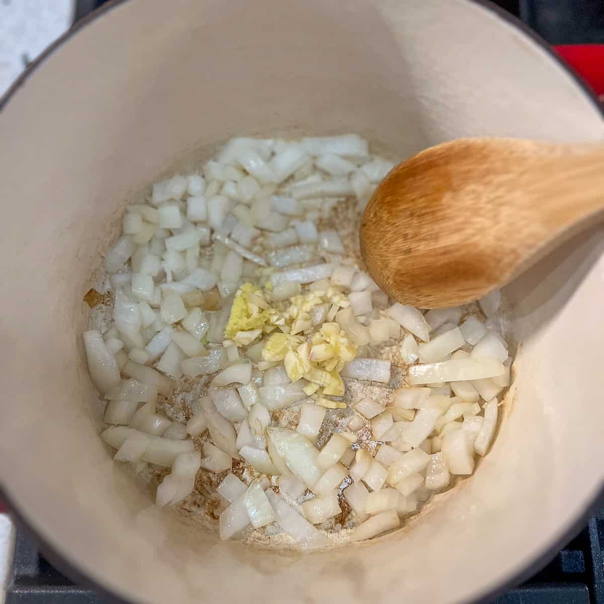 Sautéed onions in a pot with garlic and ginger.