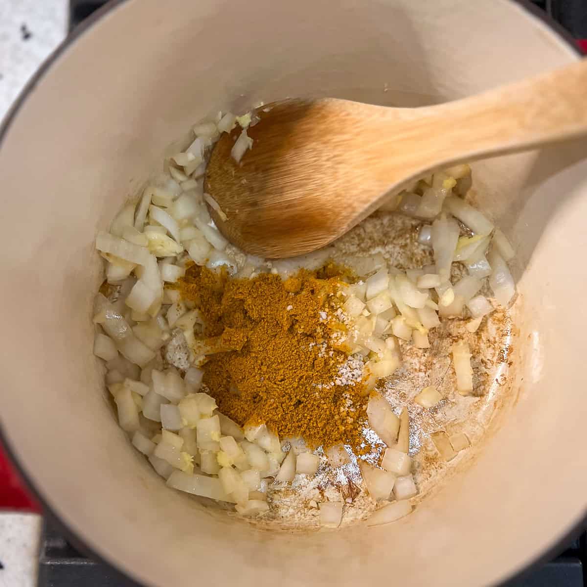 Curry powder added to the pot with onions, garlic and ginger.