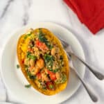 Stuffed spaghetti squash on a plate with two forks.