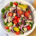 Vegan Greek salad in a bowl with fork.