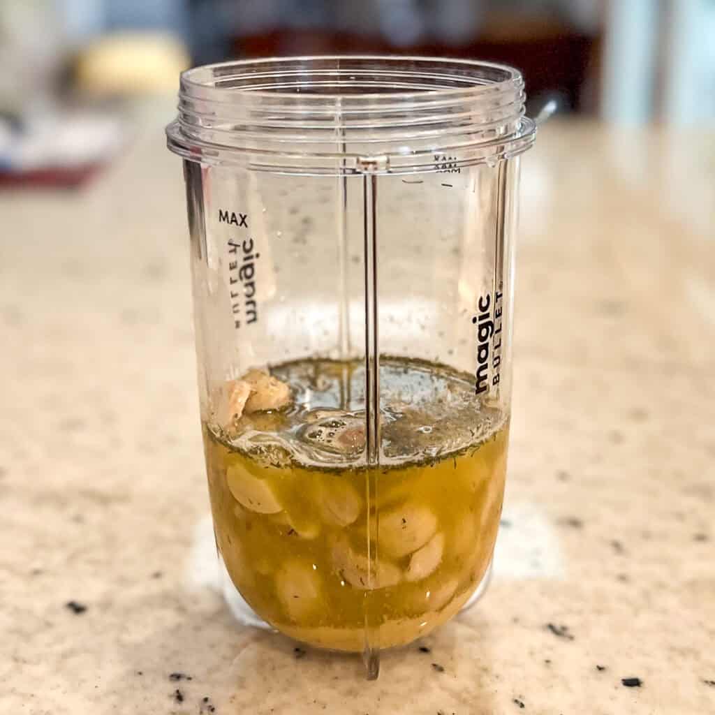 Cashews, lemon juice, water, seasonings, and apple cider vinegar in a mini blender cup before blending.