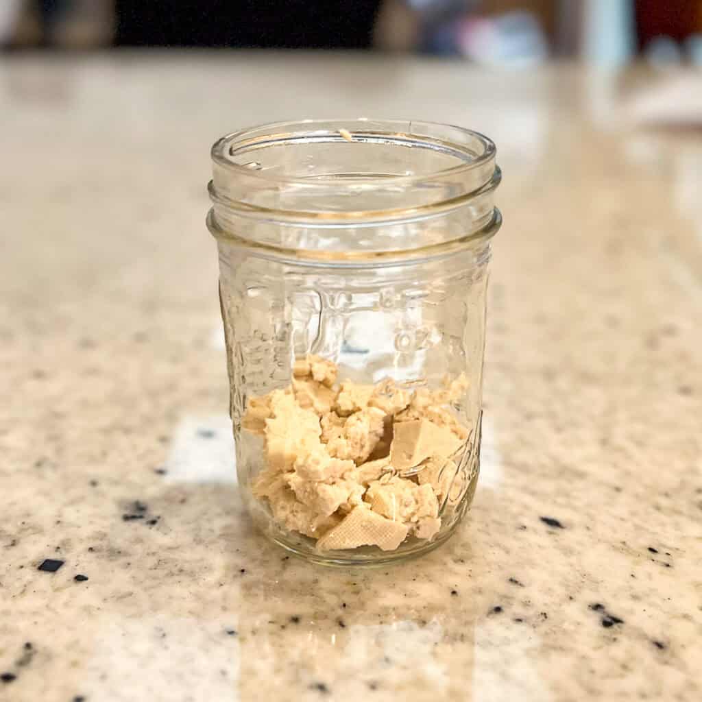 Crumbled tofu in the bottom of a mason jar.
