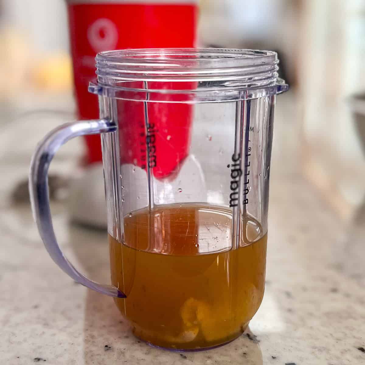 Vegetable broth and miso paste in a mini blender cup.