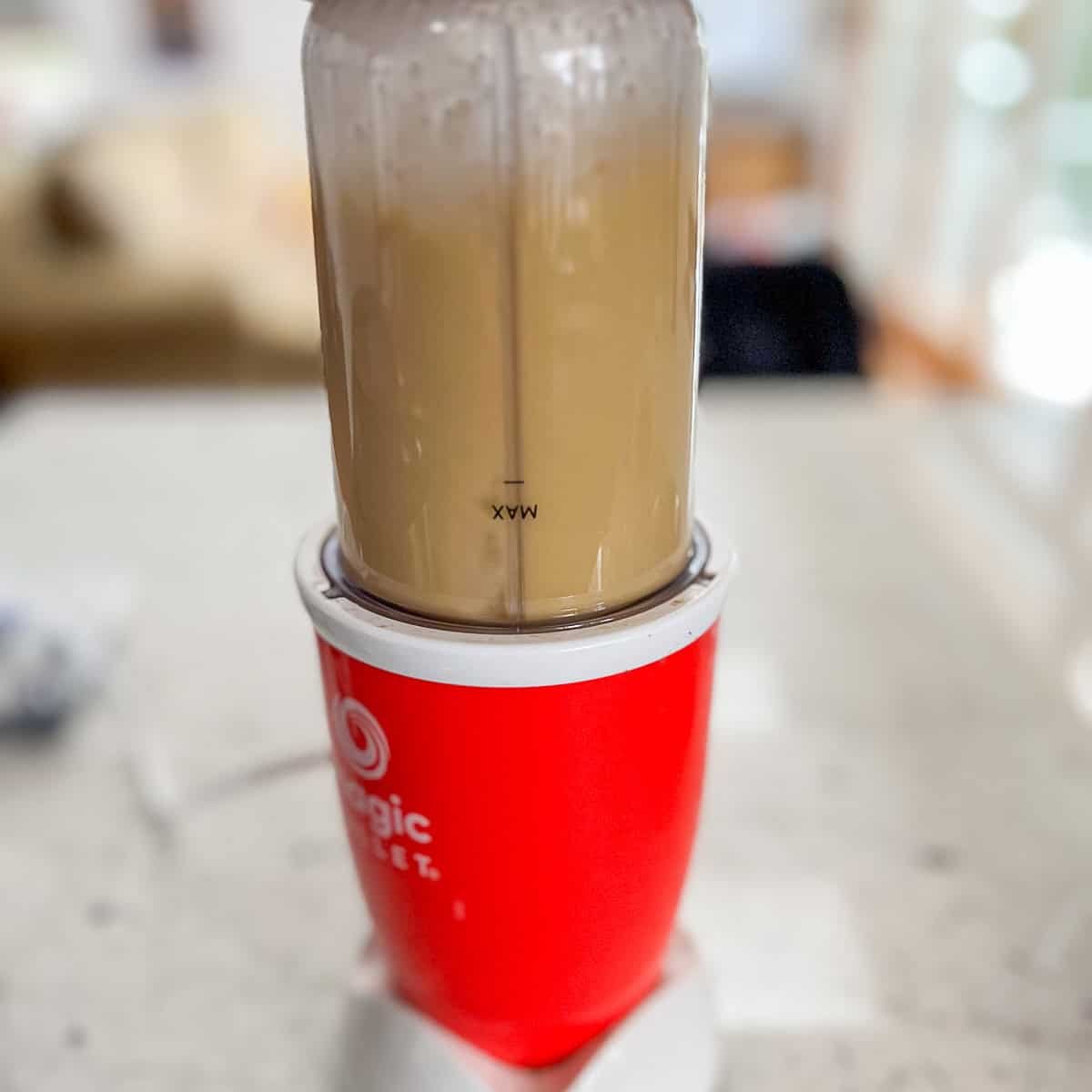 Miso paste and veggie broth being blended in a mini blender.