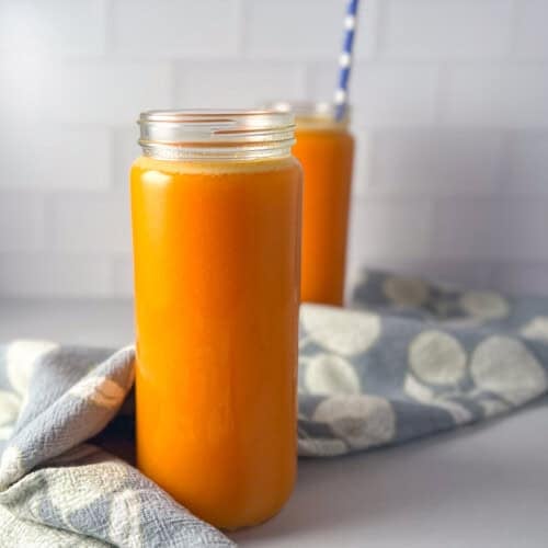 Two glasses of carrot orange lemon turmeric juice.