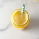 Fennel apple pineapple juice in a glass with a straw.