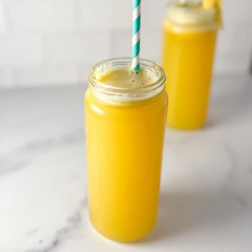 Two glasses of fennel apple pineapple juice with a straw.