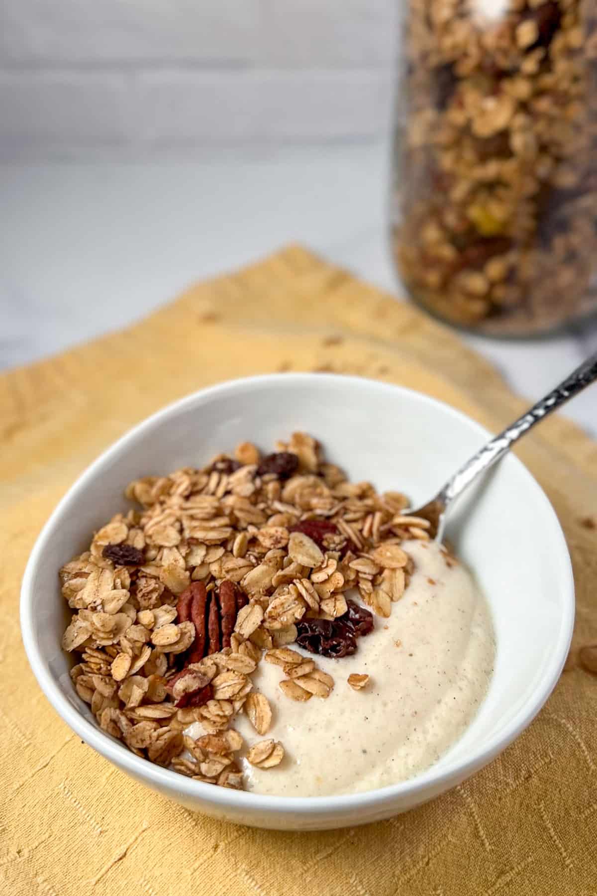 A bowl of pumpkin spice granola with soy yogurt.