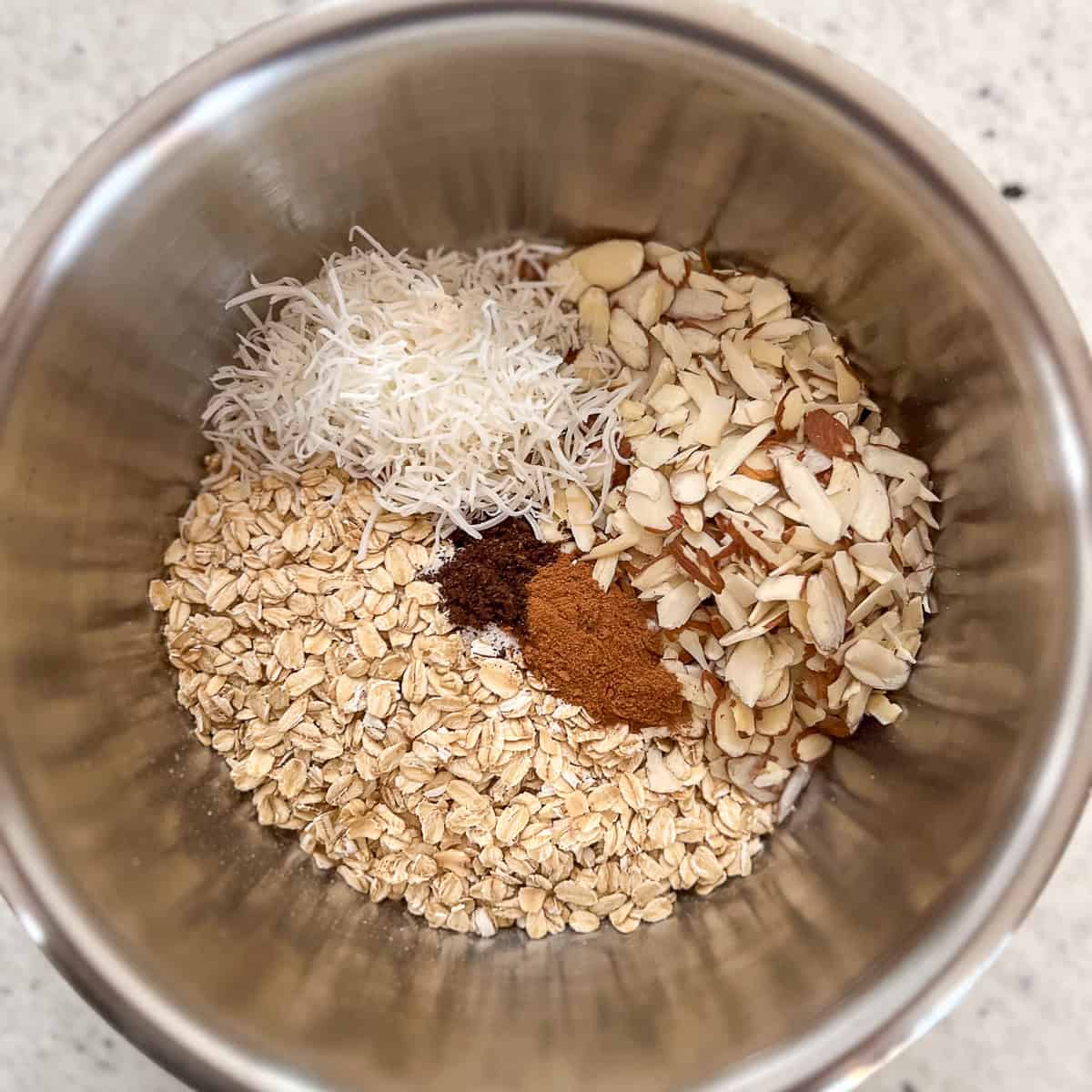 Dry ingredients for vanilla almond granola in a mixing bowl.