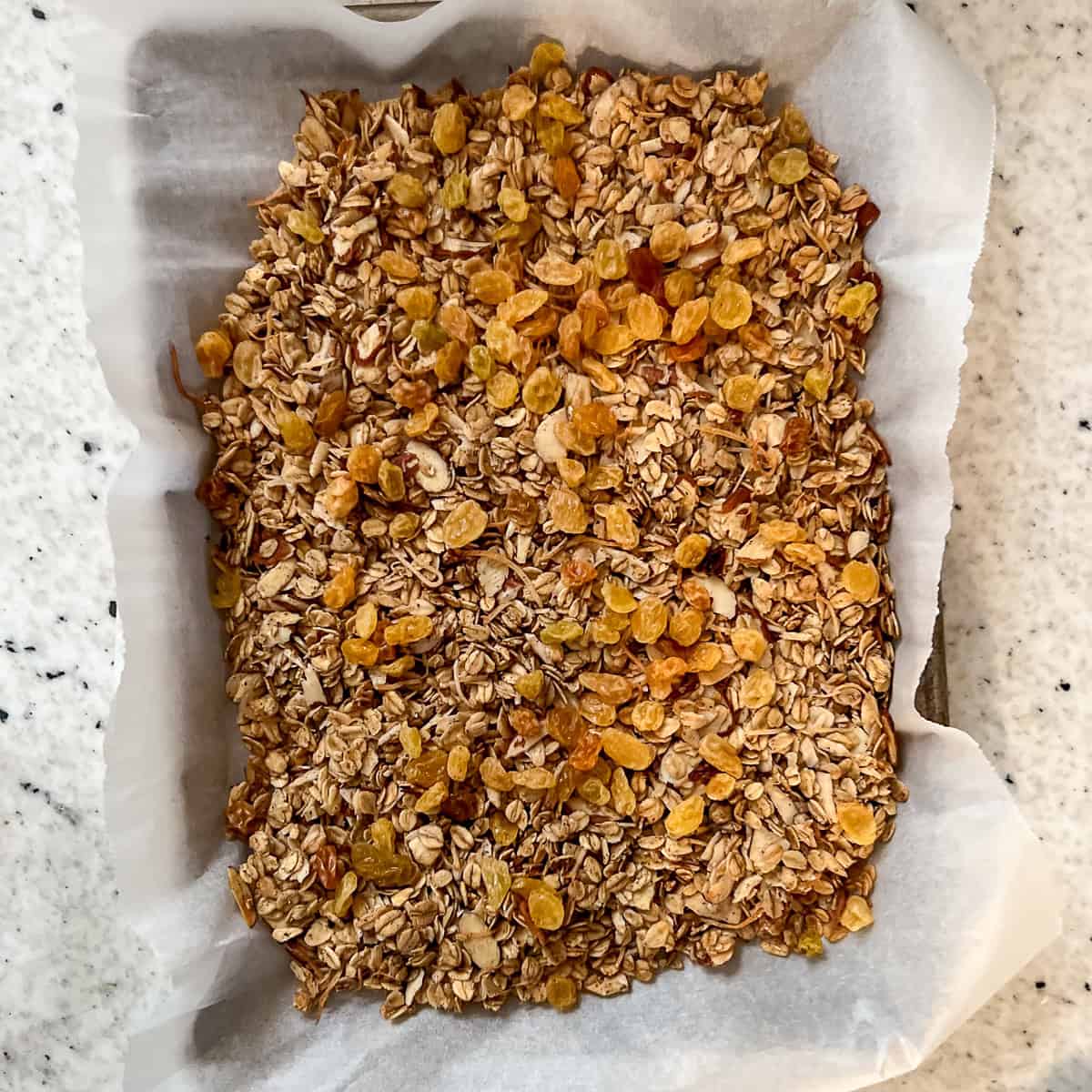 Baked granola that has cooled with golden raisins added.