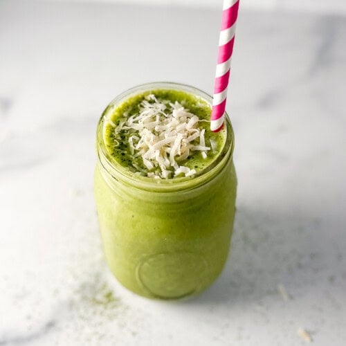 Matcha smoothie in a mason jar with straw.