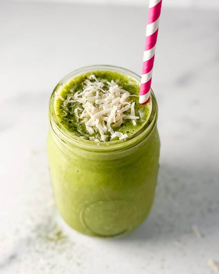 Matcha smoothie in a mason jar with straw.