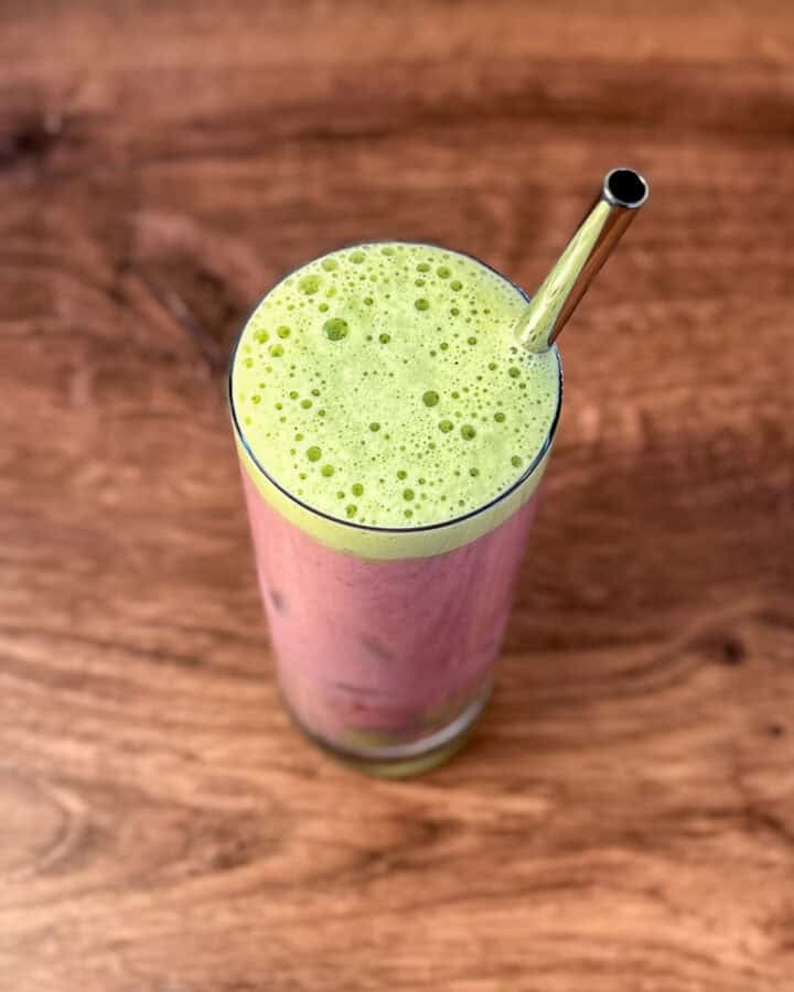 Iced Strawberry Matcha Latte in a tall glass with metal straw.