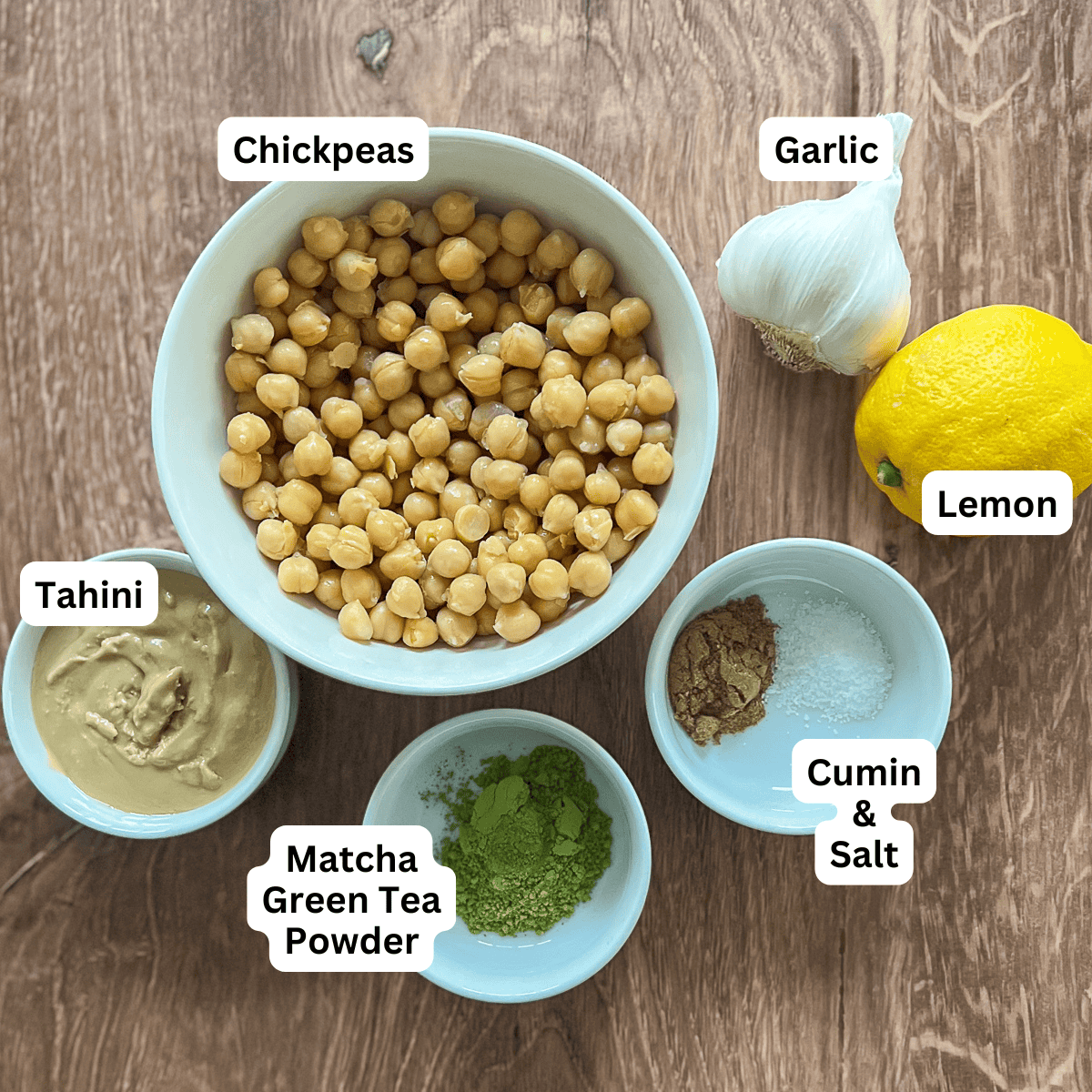 pictures of chickpeas in a bowl, tahini in a bowl, a lemon, garlic, cumin and salt in a bowl and matcha powder in bowl