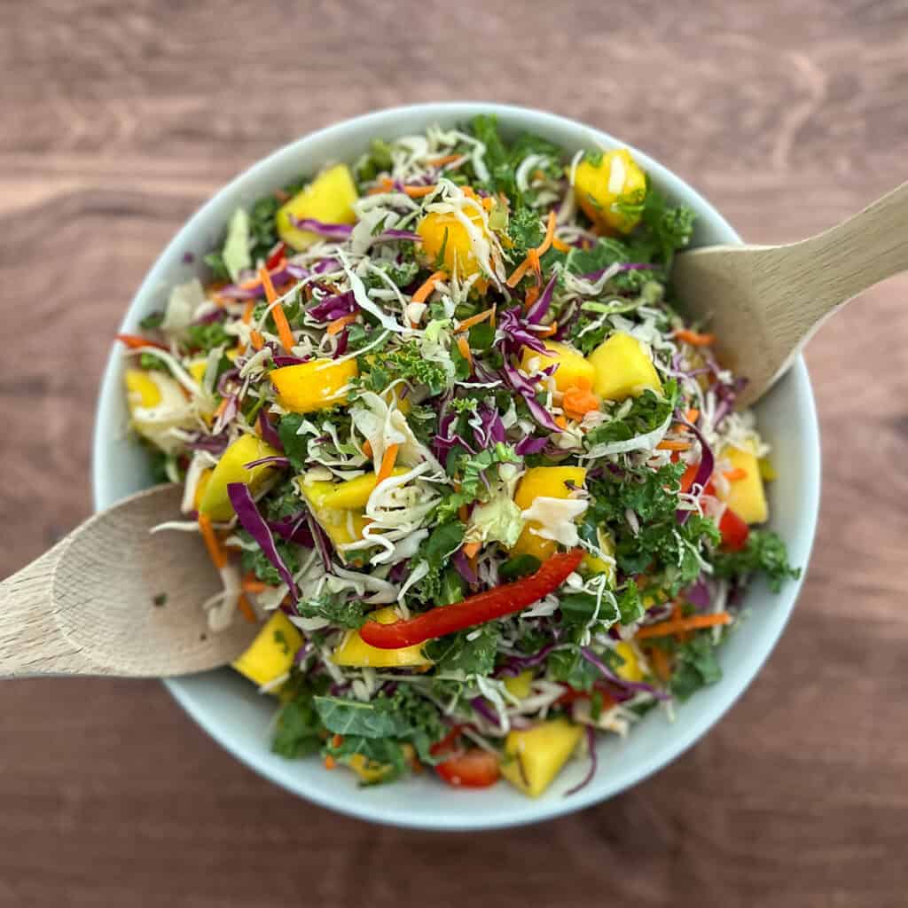 A mixed bowl of veggies with to spoons on the side.