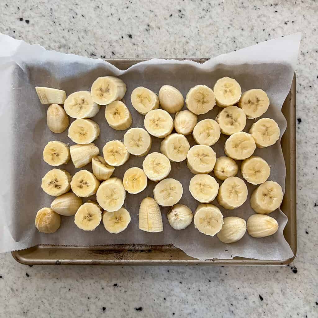 Sliced bananas into 1 to 2-inch pieces placed on a parchment-lined baking sheet for freezing.