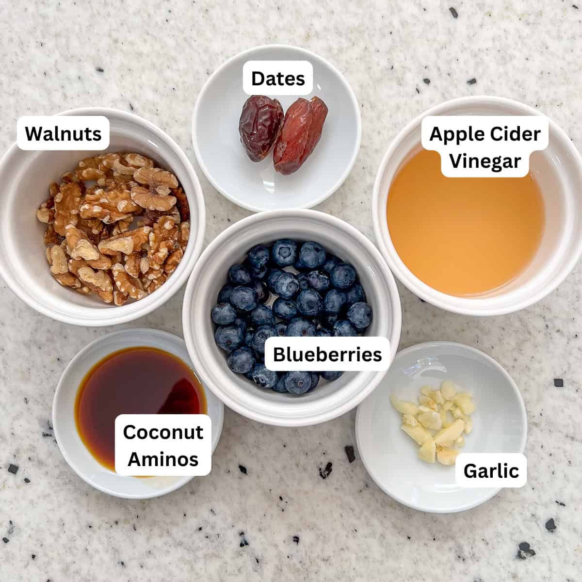 Ingredients for blueberry vinaigrette dressing: walnuts, blueberries, dates, apple cider vinegar, coconut aminos, and garlic.