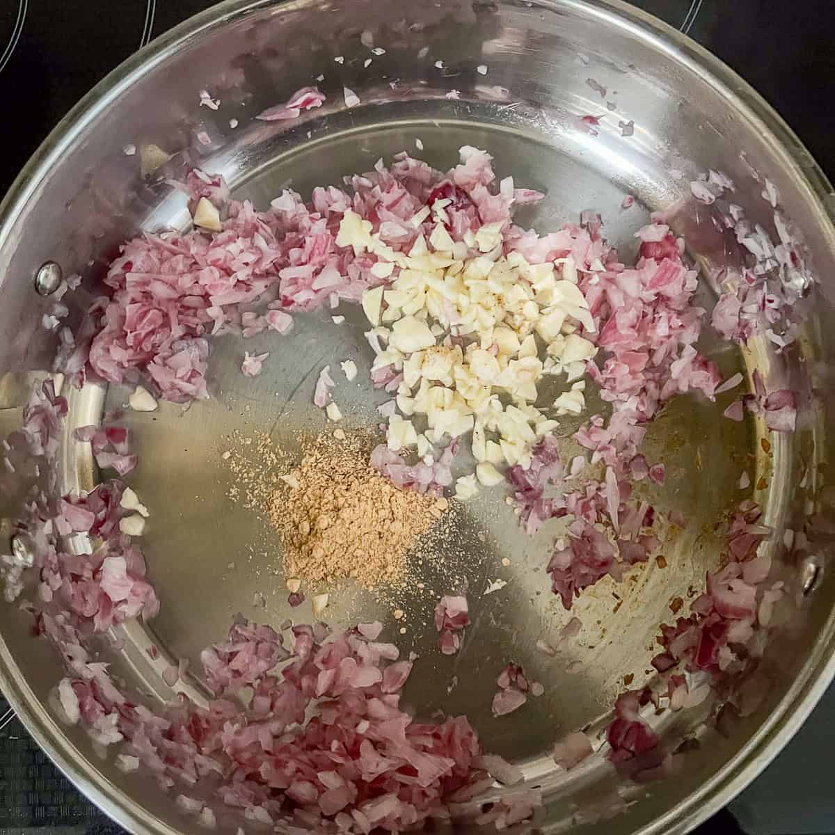 A pan with sauteed onions and garlic powder and garlic.