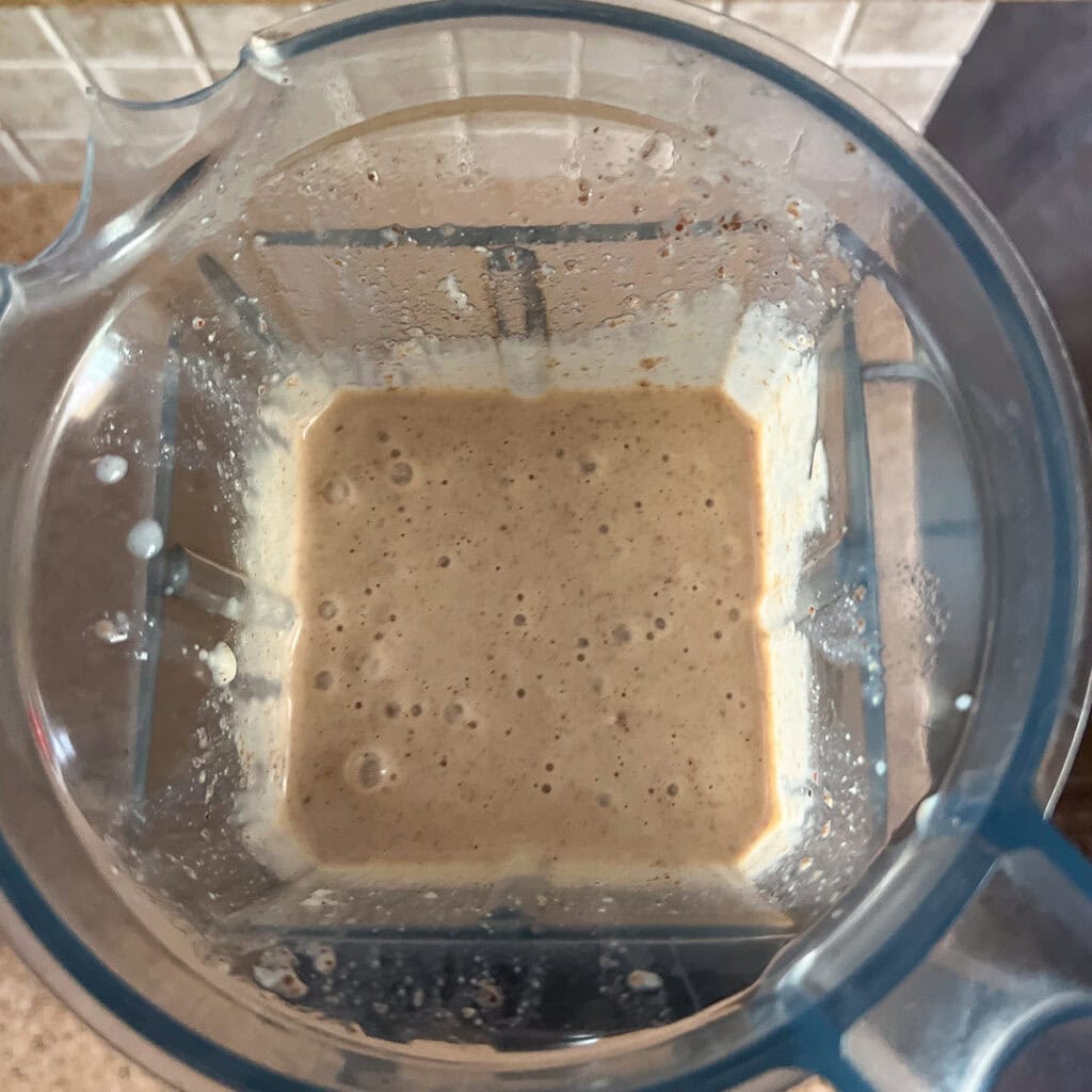 A banana smoothie with coffee blended together in a blender.
