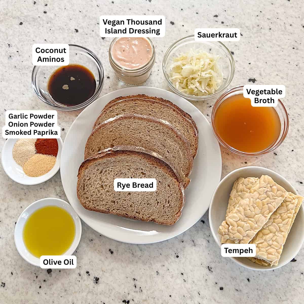 Ingredients for Tempeh Reuben Sandwich: tempeh, rye bread, coconut aminos, vegetable broth, garlic powder, onion powder, smoked paprika, olive oil, vegan thousand island dressing, and sauerkraut.