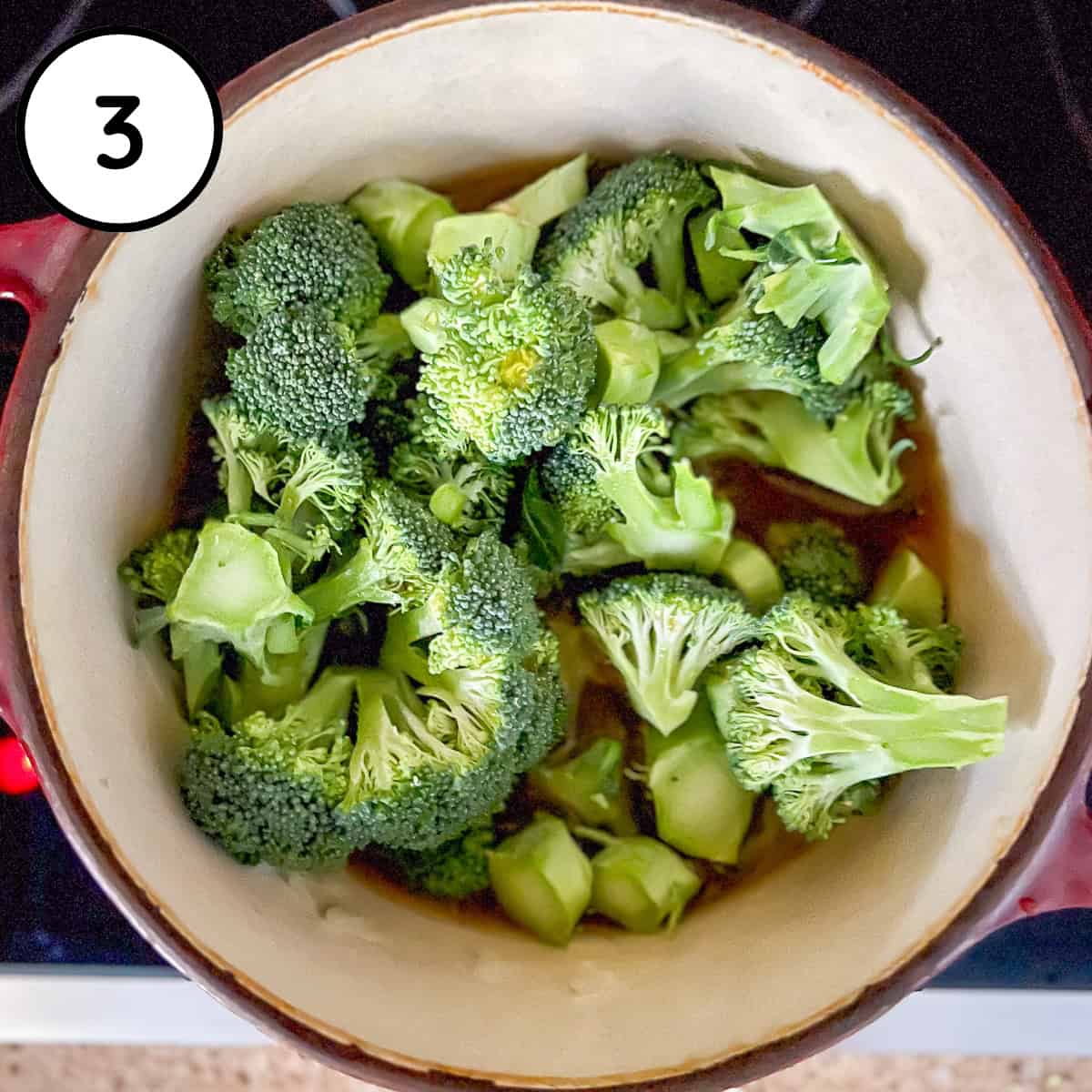Chopped broccoli in a pot with onions and garlic.