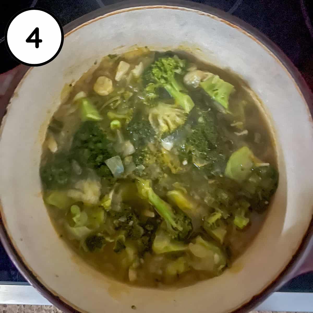 Vegetable broth added to the pot with broccoli.