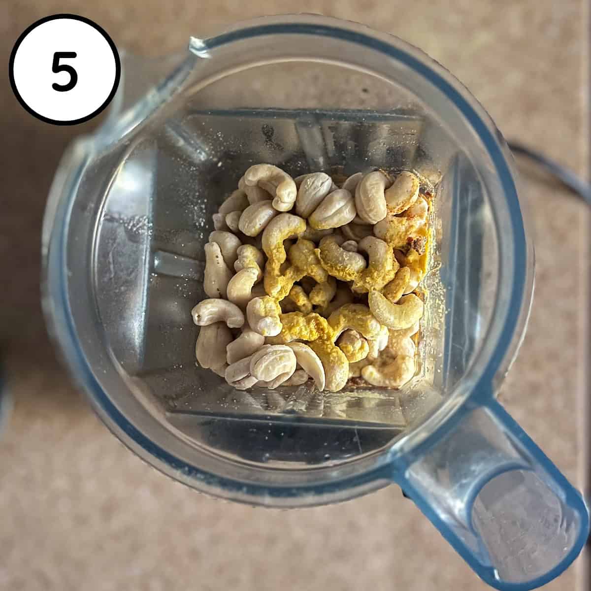 Cashews, seasonings, mustard and miso in a blender pitcher before blending.