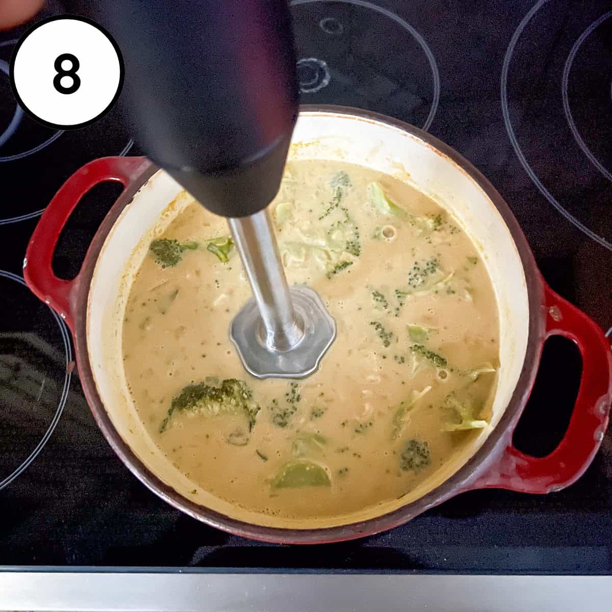 Immersion blender blending the vegan cream of broccoli soup in the pot.