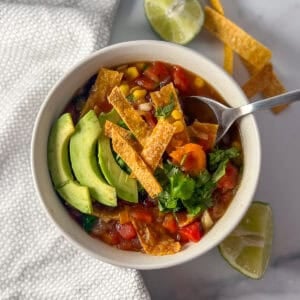 Black bean tortilla soup in a bowl with a spoon.