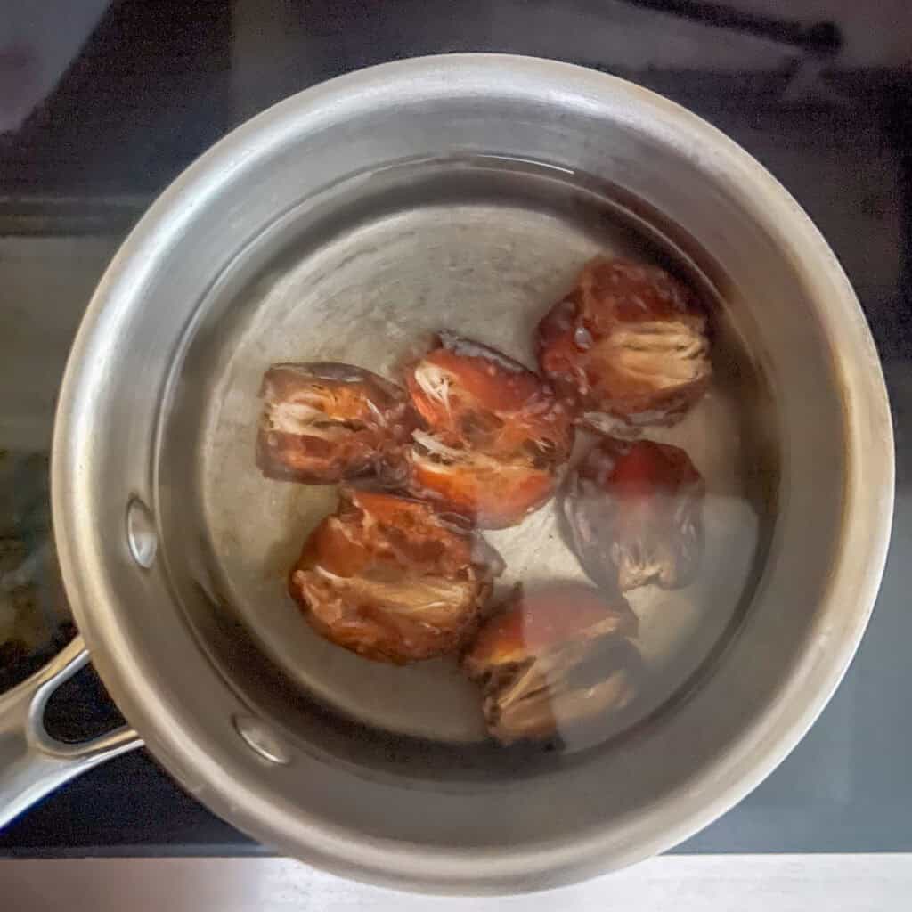 Dates in a small pot with water.