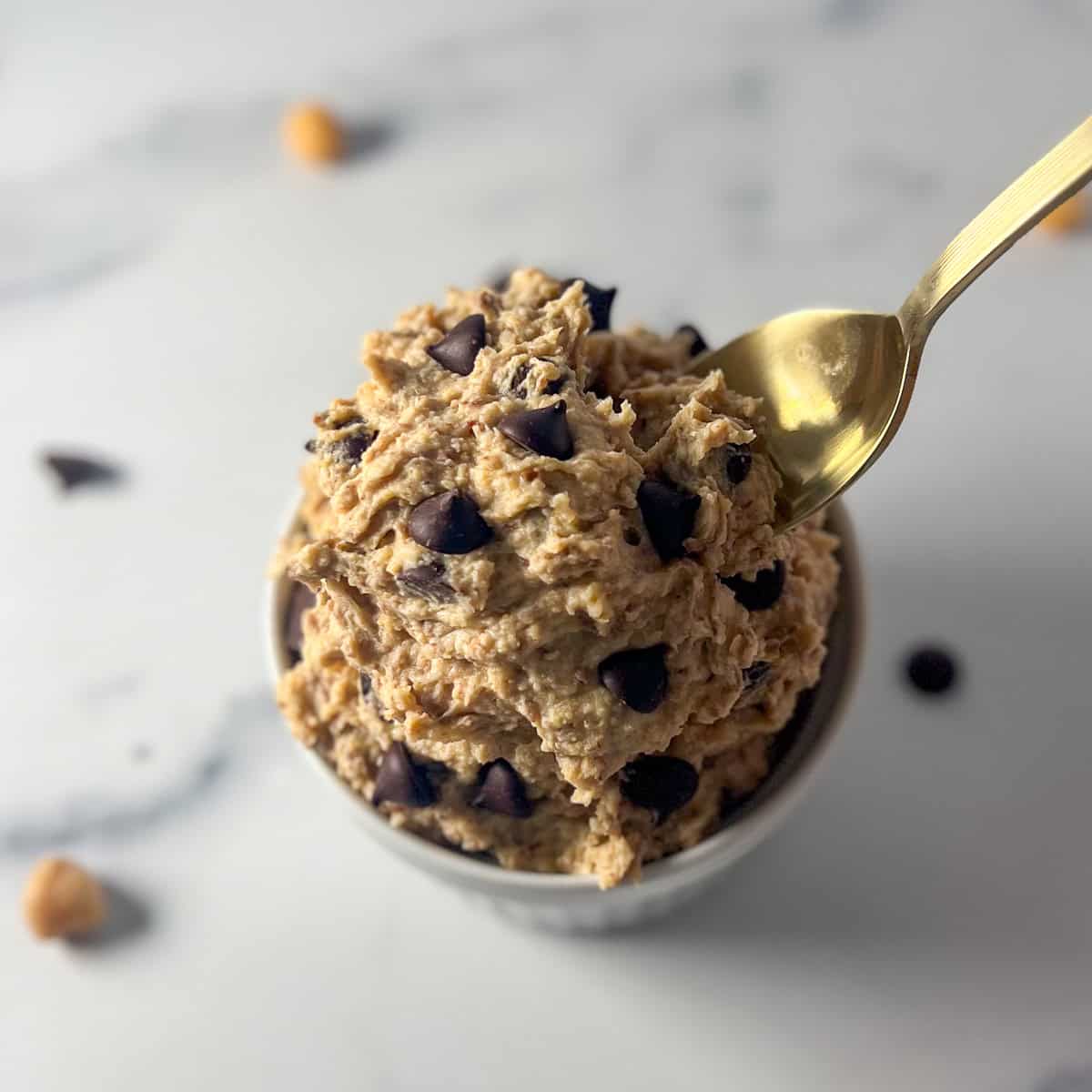 Vegan chocolate chip cookie dough in a bowl with a spoon.