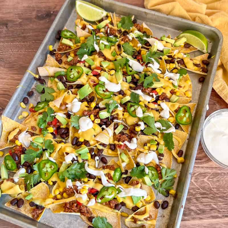 Vegan Sheet Pan Nachos on a sheet pan with cashew cream on the side.