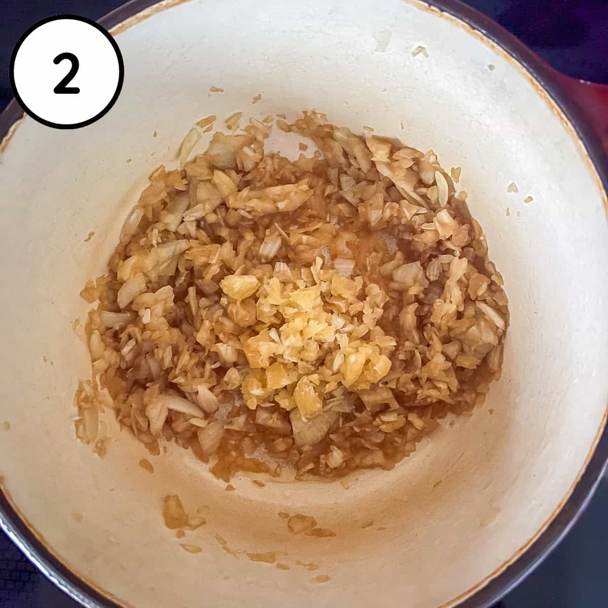 Diced onion, minced garlic and coconut aminos sautéing in a pot.