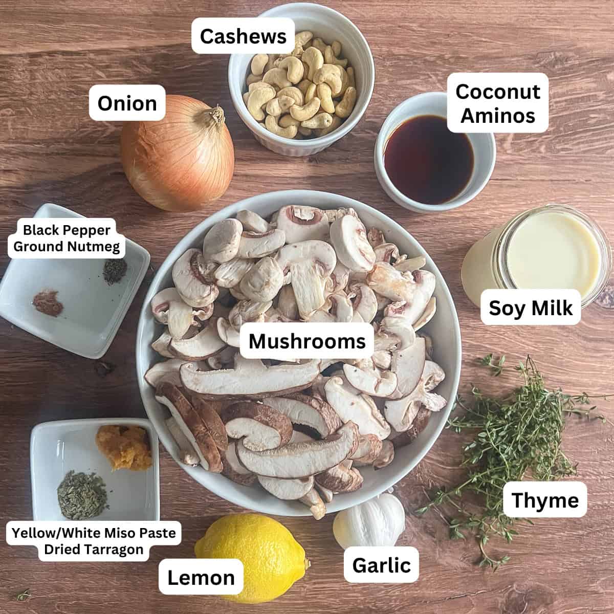 Ingredients for the Vegan cream of mushroom soup: coconut aminos, mushrooms, onion, garlic, soy milk, raw cashews, miso paste, fresh thyme, dried tarragon, black pepper, nutmeg, and lemon.