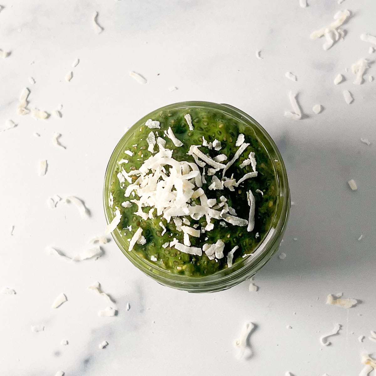Matcha chia pudding topped with shredded coconut flakes.